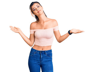 Young beautiful woman wearing casual clothes clueless and confused expression with arms and hands raised. doubt concept.