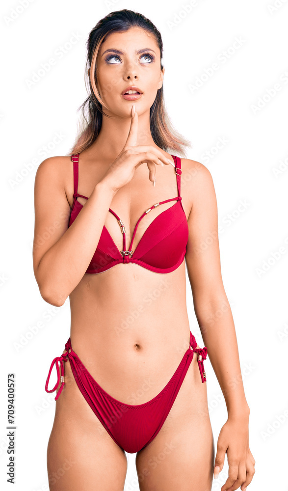 Sticker young beautiful woman wearing bikini thinking concentrated about doubt with finger on chin and looki