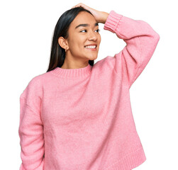 Young asian woman wearing casual winter sweater smiling confident touching hair with hand up gesture, posing attractive and fashionable
