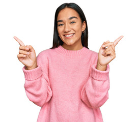 Young asian woman wearing casual winter sweater smiling confident pointing with fingers to different directions. copy space for advertisement