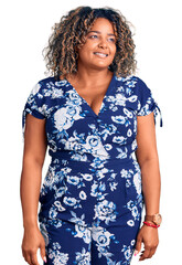 Young african american plus size woman wearing casual clothes looking away to side with smile on face, natural expression. laughing confident.