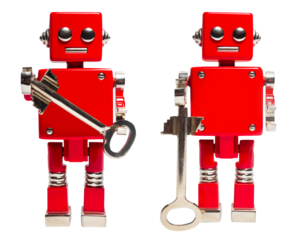 Isolated photo of red toy robot holding key on white background.