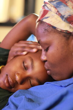 Young african mother in a headscarf with sleeping child