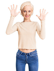 Young blonde woman wearing casual clothes showing and pointing up with fingers number ten while smiling confident and happy.