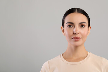 Portrait of beautiful young woman on grey background. Space for text