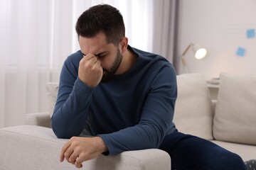 Obraz premium Man suffering from headache on sofa at home