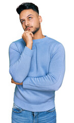 Young arab man wearing casual clothes serious face thinking about question with hand on chin, thoughtful about confusing idea