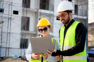 Team of architect or engineer looking laptop for inspection and planning construction at construction site, contractor or builder examining and checking project development house, industry concept.