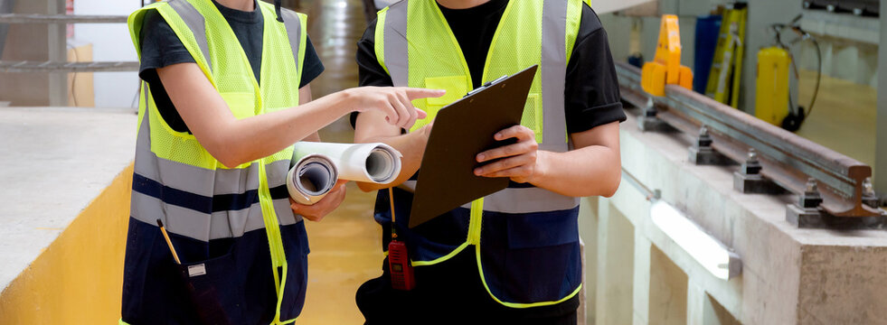 Young caucasian engineer man and woman checking electric train for planning maintenance looking document on clipboard in station, transport and infrastructure, inspector check service transport.