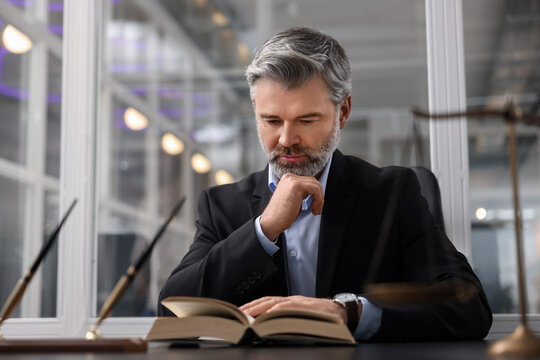 Portrait of confident lawyer at table in office