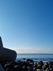 This is a Jeju beach with blue skies and basalt rocks.