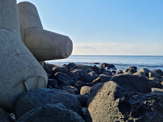 This is a Jeju beach with blue skies and basalt rocks.