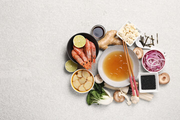 Fototapeta na wymiar Cooking delicious ramen soup. Different ingredients and chopsticks on beige table, flat lay. Space for text