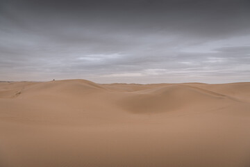 Fototapeta na wymiar Dramatic sky over the never-ending sand dunes of Gobi desert in Inner Mongolia