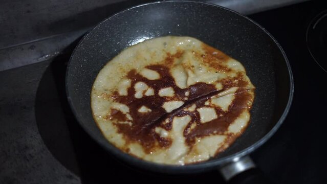 cooks pancakes in a frying pan. High quality FullHD footage