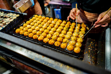 process to cooking takoyaki most popular delicious street food at Dotonbori or dotombori, Dotonbori the famous destination for traveller in Shinsaibashi, Osaka City, Osaka, Japan.