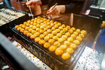 process to cooking takoyaki most popular delicious street food at Dotonbori or dotombori, Dotonbori the famous destination for traveller in Shinsaibashi, Osaka City, Osaka, Japan.