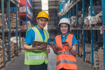 Warehouse management team using computer laptop check stock inventory. Asian men women worker use...