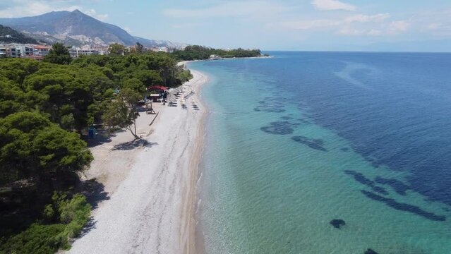 A drone flies parallel to the beach above the small town of Xylokastro in Greece
