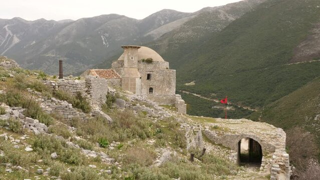Remains of ancient Ottoman mosque with half-destroyed minaret on rocky hilltop of Sopot hill near Borsh village in Albania on spring day. High quality 4k footage