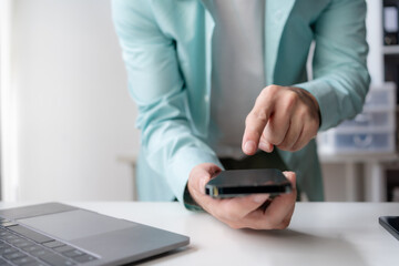 Close up of hands man hand using smartphone typing, chatting conversation in chat box. Man hands using smartphone in office, messaging or browsing social networks.