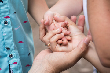 Little kid holding family member mother hand as a together family