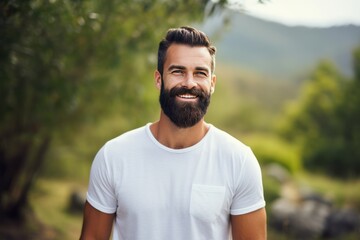 Portrait of a handsome bearded man smiling isolated on nature background. 