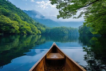 Obraz premium A serene lake surrounded by lush forests and mountains in the background A canoe floating gently on the water