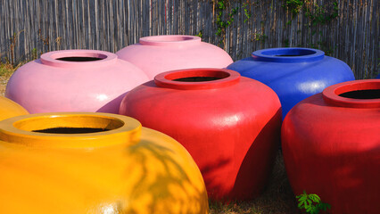 Group of large colorful water jars with a capacity of 2000 liters of water for sale in rural...