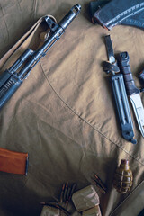 Kalashnikov assault rifle, cartridges, F-1 grenade and bayonet knife. Top view copyspace