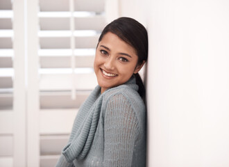 Indian woman, portrait and smile in a new home relax in the morning. Lounge, happy and female person face with mockup space, real estate and calm in a house leaning on a room wall in a bedroom