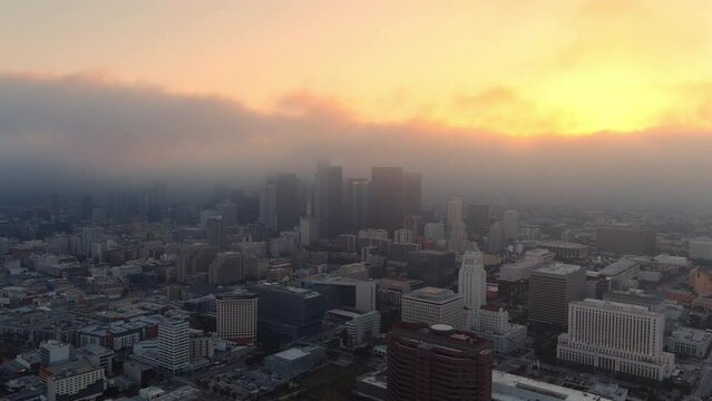 Serene aerial view of a foggy Los Angeles skyline at golden hour