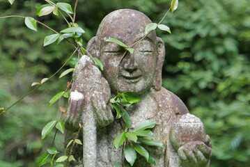 森の中にあるお地蔵様の顔のアップ　地蔵　緑　木　山の中　