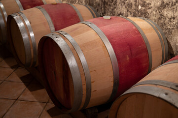 French oak wooden barrels for aging red wine in underground cellar, Saint-Emilion wine making...