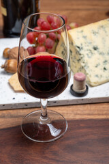 Red porto and cheese pairing, blue matured stilton English cheese served as dessert with walnuts and glass ruby porto wine