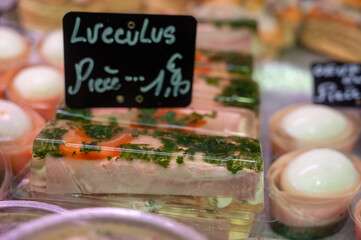 Assortment of meat on weekly food market in France, English translation: cow's tongue in jelly