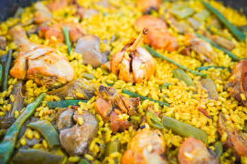 Valencian paella with a rich variety of ingredients in a pan.