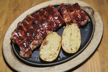 Costillas de cerdo con salsa barbacoa y patata asada