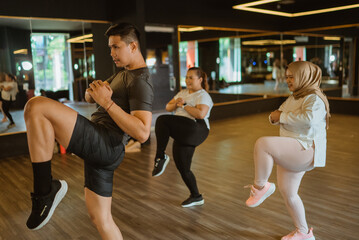 professional male instructor training fitness class trainee in gym