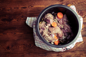 Beef, onion, carrot, garlic and spices in a metal pot before stewing. Slow cooking concept. Retro style photo, copy space