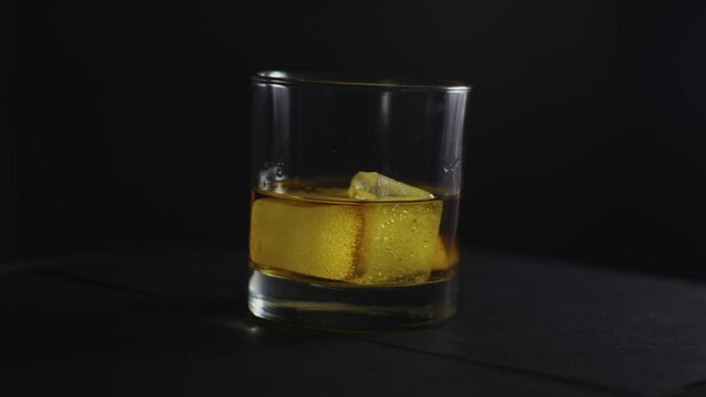 Whiskey Glass Rotating on Black Background