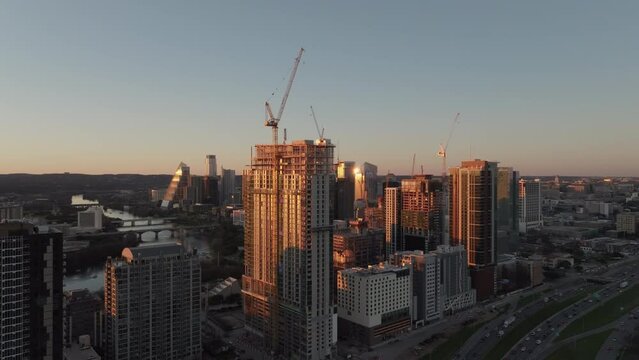 Skyscraper construction with cranes and high-rise buildings in modern American city. Aerial