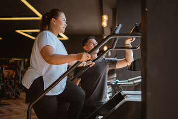 plus size woman doing cardio work out for wight loss program with her personal trainer