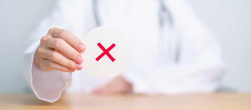 Doctor show Wrong symbol paper. True and false, accept and rejected, evaluation, Diagnosis, Vote, Poll, Yes or No, Health, Medical and Survey concepts
