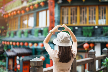 woman traveler visiting in Taiwan, Tourist with hat sightseeing in Jiufen Old Street village with Tea House background. landmark and popular attractions near Taipei city . Travel and Vacation concept - obrazy, fototapety, plakaty
