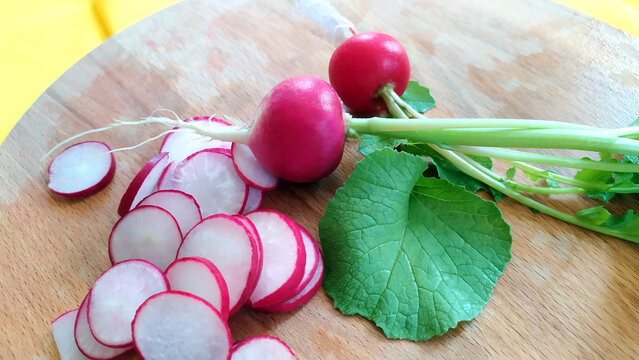 Close-up of radish slices. View from above. Radish roots lie on a cutting board. Early vegetables are ready for diet salads.