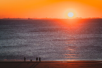 Spaziergänger am Meer im Sonnenuntergang