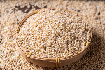 Sorghum seeds in bamboo basket closeup. Whole seeds of Sorghum Moench