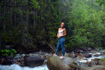 Naklejka na ściany i meble Young woman near Kezmarska Biela voda, the creek from the Tatra mountain in the valley