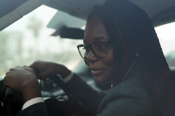 Black woman wearing smart casual sitting in the car